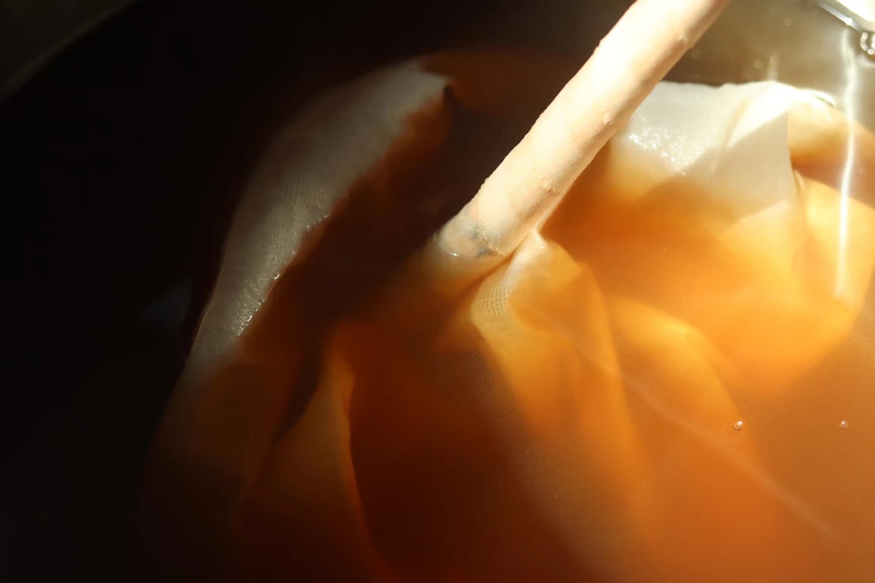 Textile immersed in a warm-toned dye bath during development.
